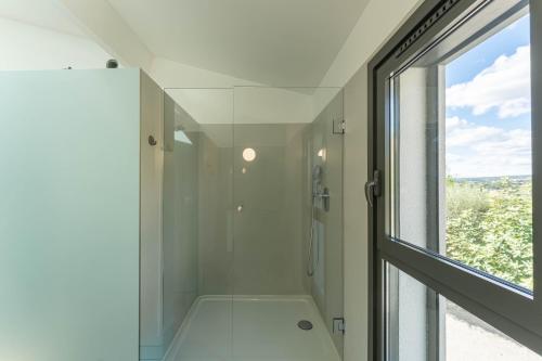a glass shower in a bathroom with a window at Albaé - Climatisé - Piscine - Parking - Provence in Allauch