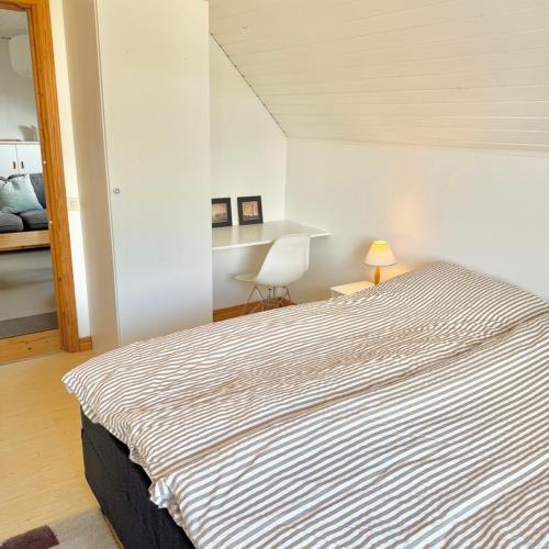 a bedroom with a large bed with a striped blanket at Light-filled and spacious villa on Vrångö Island in Vrångö