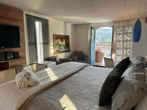 a bedroom with a large bed with towels on it at Suítes Hortênsias in Lavras Novas