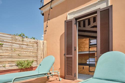 a blue chair sitting on a balcony with a window at JO&JOE ROMA in Rome
