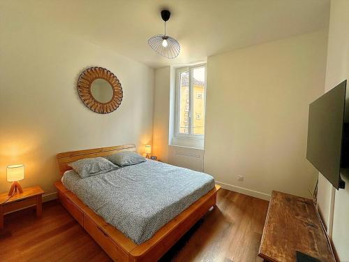 a bedroom with a bed and a mirror on the wall at Appartement de standing tout confort, Aups in Aups