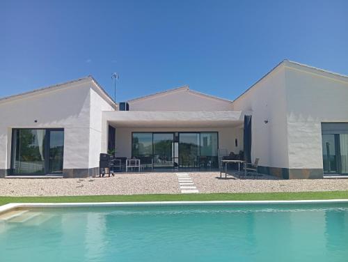 a house with a swimming pool in front of it at Casa Rural La Yesería Alcocer in Sacedón
