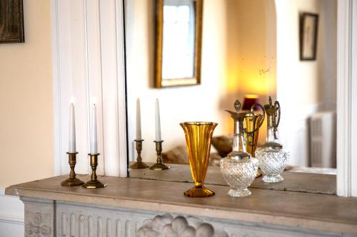 a table with several candles and vases on it at Hattonchatel Château & Restaurant La Table du Château in Hattonchâtel