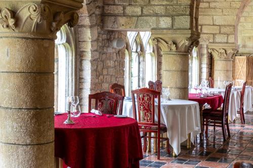 a dining room with red tables and chairs in a castle at Hattonchatel Château & Restaurant La Table du Château in Hattonchâtel