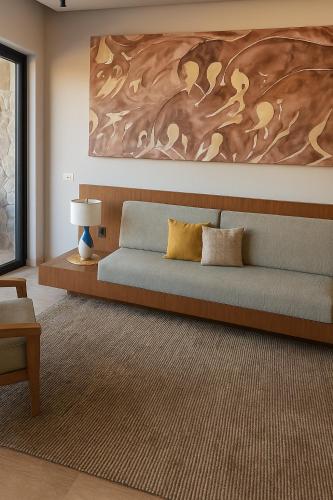 a bedroom with a bed with a painting on the wall at Hotel Flores de Sal-Valle de Guadalupe in Valle de Guadalupe