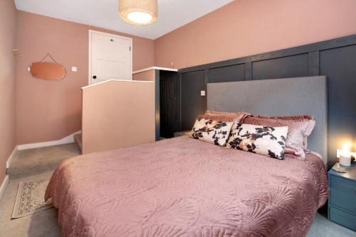 a bedroom with a large bed with a large headboard at Pinewood Lodge in South Brent