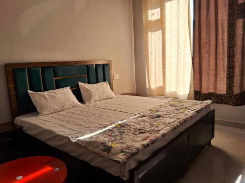 1 cama grande con cabecero verde en un dormitorio en AAAC HoME STAY, en Sundarnagar