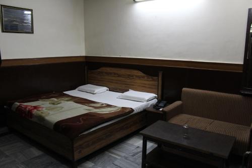 a small bedroom with a bed and a table at Hotel Ajay International in Agra