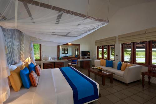 a bedroom with a bed and a living room at Habarana Village by Cinnamon in Sigiriya