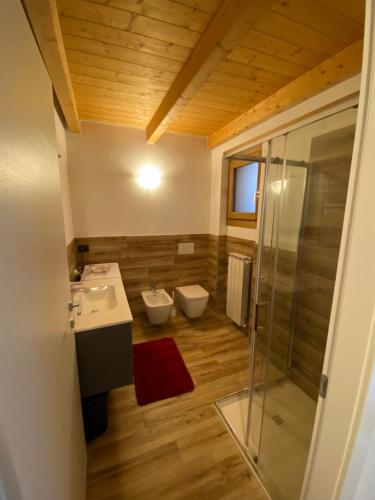Un baño con inodoro, lavabo y ducha. en Residenza Colere Ski 2024, en Colere