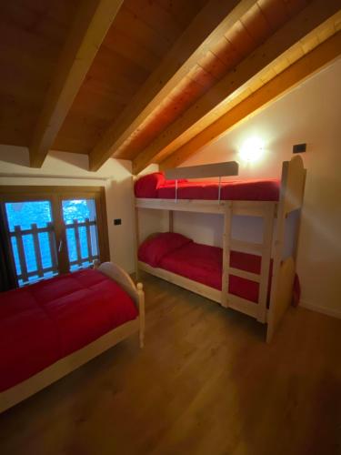 Un dormitorio con dos literas en una cabaña. en Residenza Colere Ski 2024, en Colere
