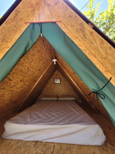 ein Zelt mit einem Bett in der Mitte in der Unterkunft Cabana Ipê - Nosso Quintal Candeias in Conceição do Mato Dentro