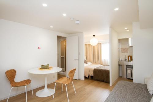 a living room with a table and chairs and a bedroom at M House Tokyo Omori駅 in Tokyo