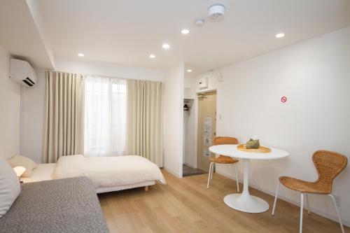 a bedroom with a bed and a table and chairs at M House Tokyo Omori駅 in Tokyo