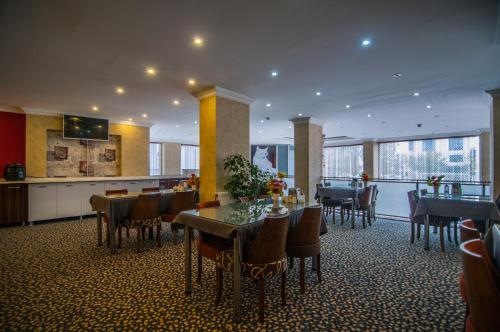 a dining room with tables and chairs and a kitchen at Hotel Dosco in Van