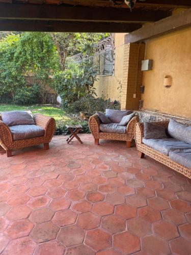 two wicker chairs sitting on a brick patio at Casa bonita in Tepoztlán