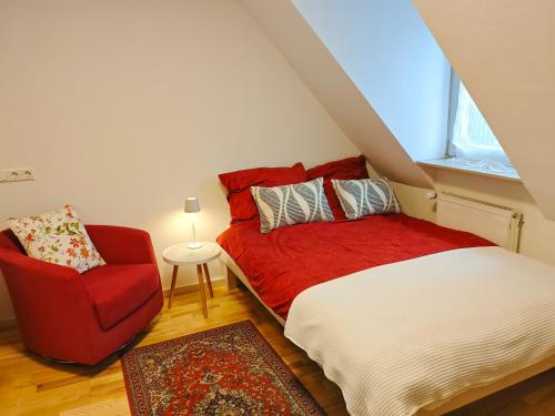 a bedroom with a red bed and a red chair at ZEN Apartment 2 rooms Maisonette Bright and Spacious in Karlsruhe
