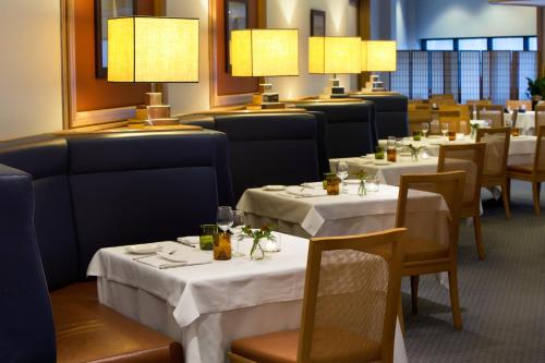 a dining room with tables and chairs and lights at Starhotels President in Genova