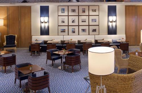a restaurant with tables and chairs and pictures on the wall at Starhotels President in Genova