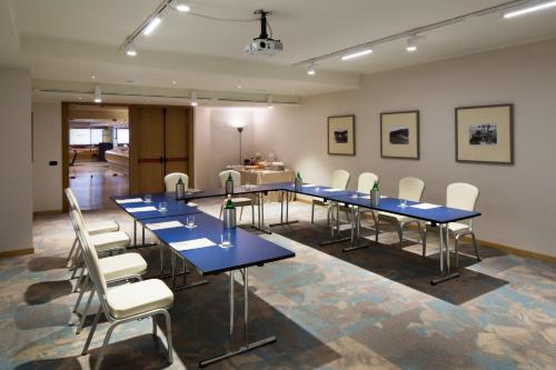 a conference room with blue tables and white chairs at Starhotels President in Genova