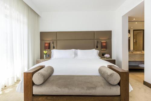 a bedroom with a large bed with a white bedspread at NH Collection Bogotá Royal Teleport in Bogotá