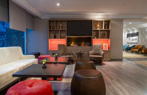 a living room with a couch and a fireplace at Leonardo Hotel Hannover in Hannover