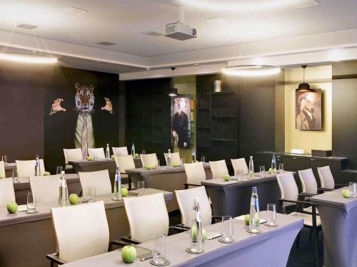 a conference room with tables and chairs and a picture of a monkey at Le Louise Hotel Brussels - MGallery Collection in Brussels