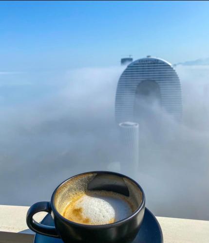 a black cup of coffee sitting on a table at ORBI CITY LUXURY deluxe KIG DVD in Batumi