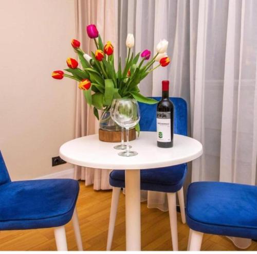 a table with a bottle of wine and a vase of flowers at ORBI CITY LUXURY deluxe KIG DVD in Batumi