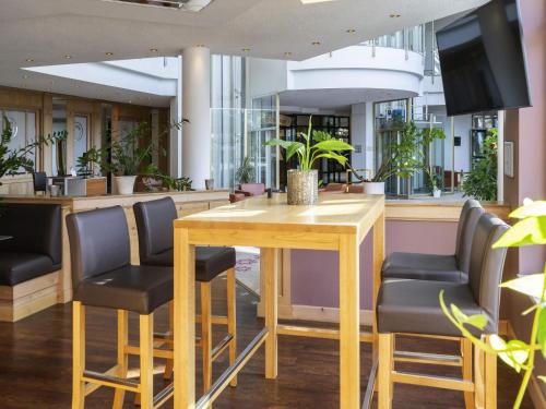 a conference room with a wooden table and chairs at Atomis Hotel Munich Airport by Mercure in Oberding