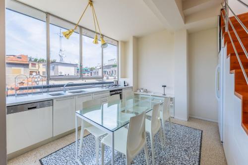une cuisine avec une table en verre et des placards blancs dans l'établissement Penthouse Milan Center Jacuzzi & Garage, à Milan