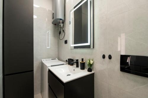 a bathroom with a white sink and a mirror at Lavena Charming Stay in Old Town Labin in Labin