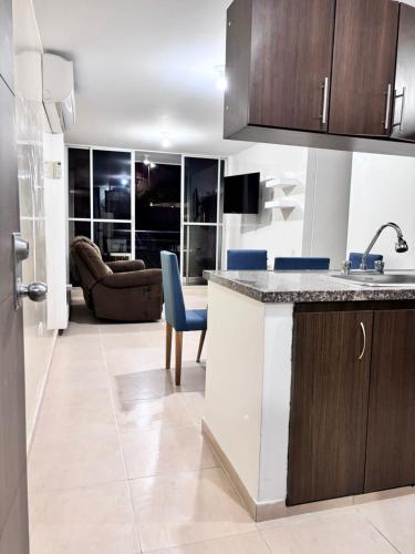 a kitchen with a counter top and a living room at Apartamento colonial en Girón in Girón