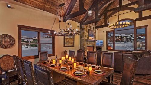 a dining room with a table and chairs and a chandelier at Appaloosa Mountain Lodge in Steamboat Springs
