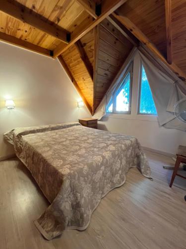 a bedroom with a bed in a attic at Casa Matteo con quincho, patio y cochera in Las Grutas