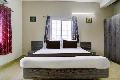 a bedroom with a large bed in front of a window at Hotel O Silver Sky in Gulbarga