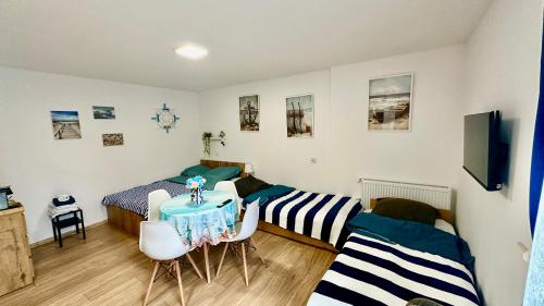 a bedroom with two beds and a table and chairs at Apartament nr 4 przy Sali Kominkowej in Przeczyce