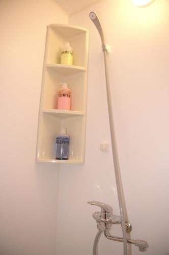 a bathroom with a shelf with three candles on it at Guesthouse Haru Kitamachi in Nara