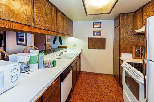 una cucina con armadi in legno e lavandino bianco di Horizons 4 - Pool & Hot Tub Access a Mammoth Lakes