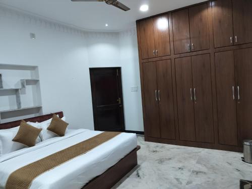 a bedroom with a large bed and wooden cabinets at Aara - Boutique stay in Udaipur