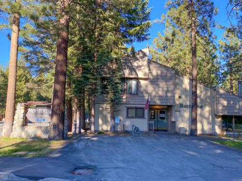 a white house with trees in front of a driveway at Horizons 4 - Pool & Hot Tub Access in Mammoth Lakes