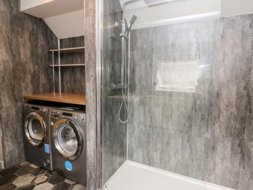 y baño con ducha y lavadora. en 6 Upperfield Street, en Dolgellau