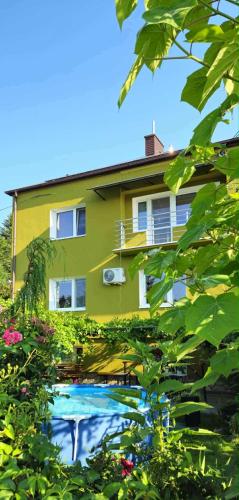 a house with a swimming pool in front of it at Zakątek u Poety Dąbrówka in Jasło