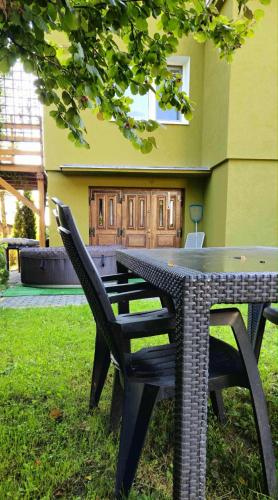 a wicker table and chairs sitting in front of a building at Zakątek u Poety Dąbrówka in Jasło