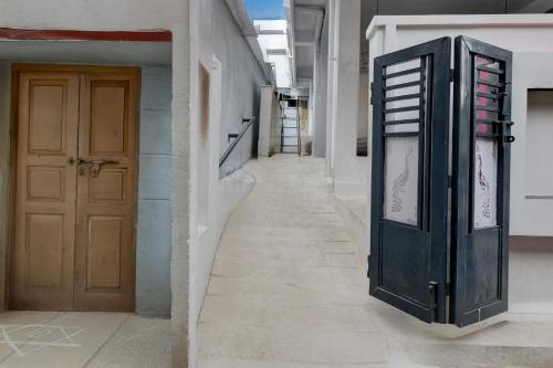 a hallway of a building with a door and a sidewalk at Hotel O Sun Lodge in Hyderabad