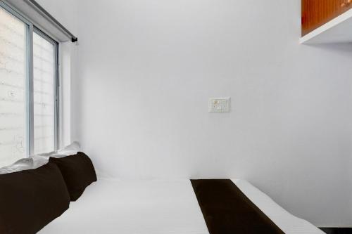 a white room with a bed and a window at Hotel O Sun Lodge in Hyderabad
