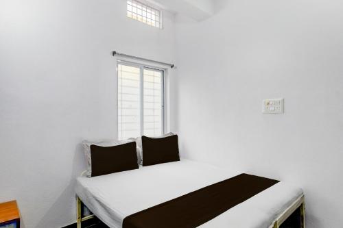 a bed in a room with a window at Hotel O Sun Lodge in Hyderabad