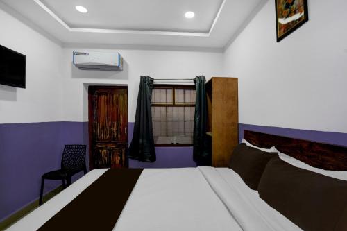 a bedroom with a bed and a window at Hotel O P R S Elite in Surūrnagar