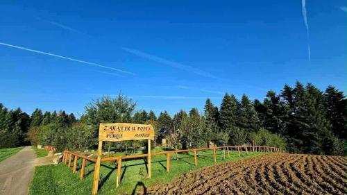 a sign in the middle of a field with a dirt road at Zakątek u Poety Dąbrówka in Jasło