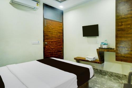 Un dormitorio con una cama y un televisor. en Hotel O JAIPUR ONE, en Jaipur
